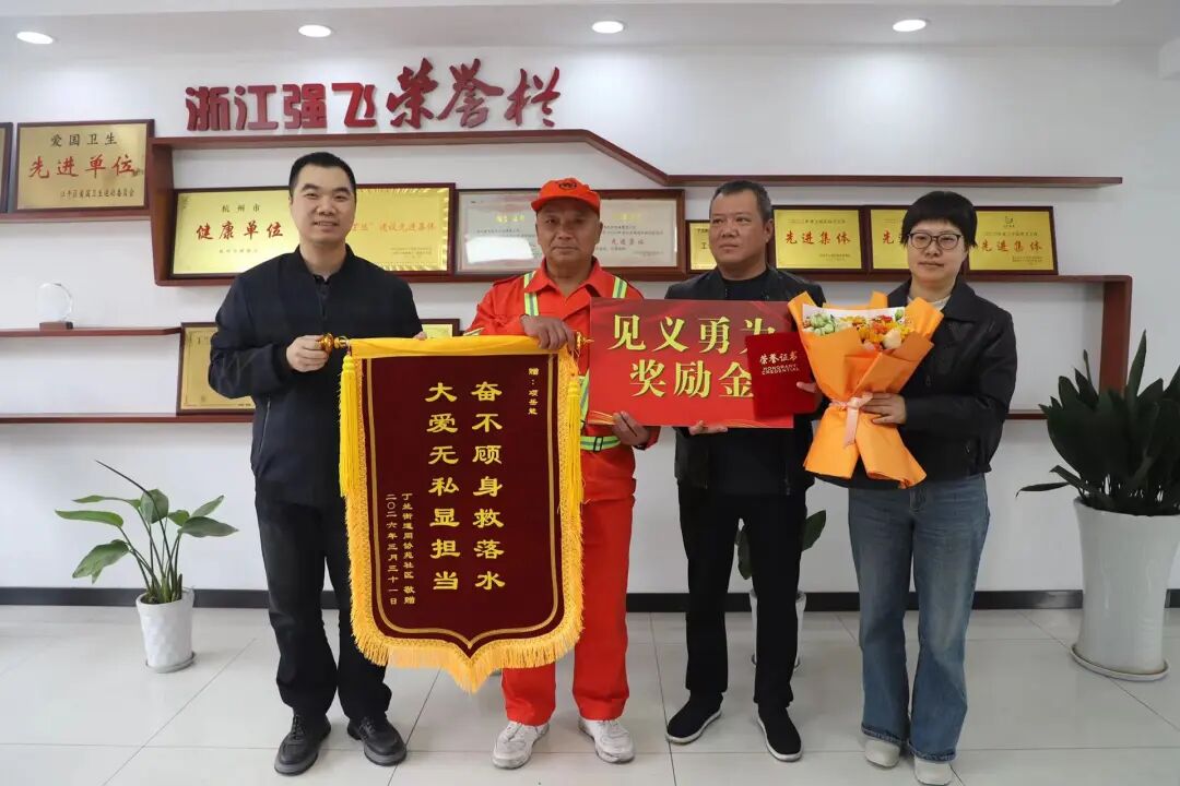 丁兰街道相关负责人、社区代表及浙江强飞环卫保洁有限公司共同向项岳能赠送锦旗,并颁发见义勇为奖励金